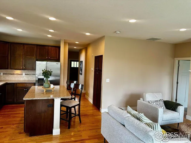 a kitchen with stainless steel appliances granite countertop a sink table and chairs