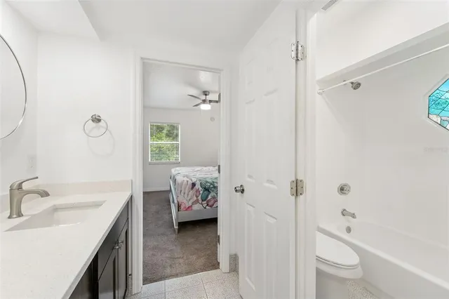 a living room with a bed furniture and a flat screen tv