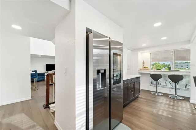 a large kitchen with kitchen island a large counter top space a sink a stove and wooden floor