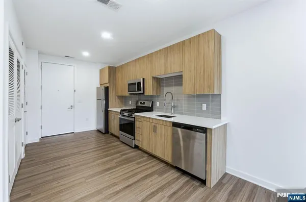 a large kitchen with a wooden floor and a sink