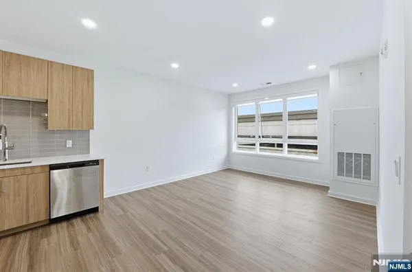 a view of a kitchen with a sink and dishwasher stove top oven with wooden floor