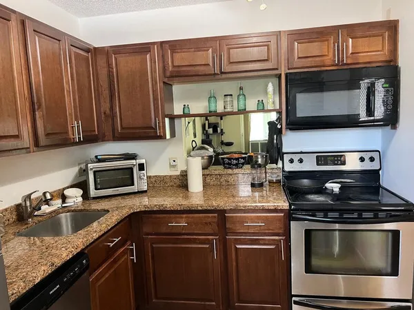a kitchen with stainless steel appliances granite countertop a stove microwave and sink