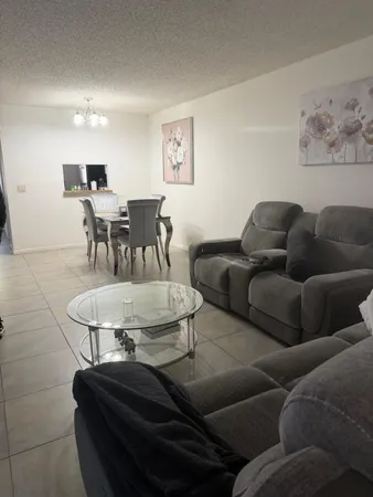 a living room with furniture and a dining table with wooden floor