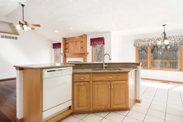 a view of an empty room with a window and chandelier