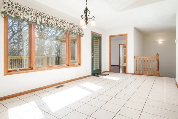 a view of a room with wooden floor chandelier and a window