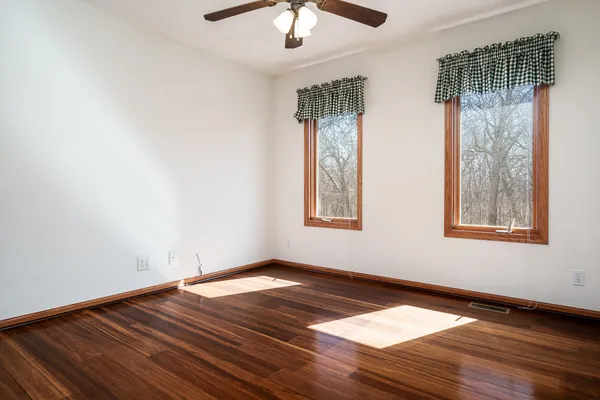 a view of empty room with wooden floor