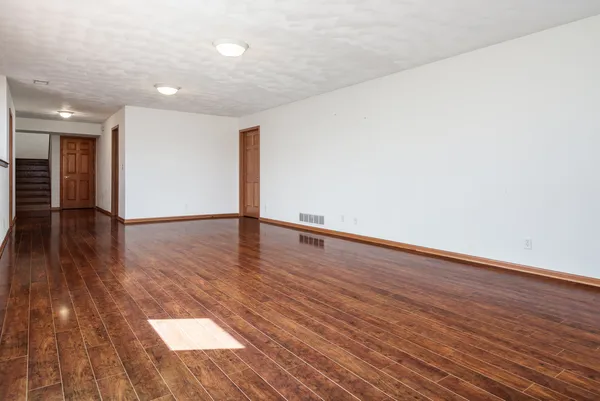 a view of an empty room with wooden floor