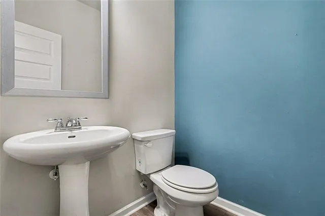 a bathroom with a sink a toilet and mirror