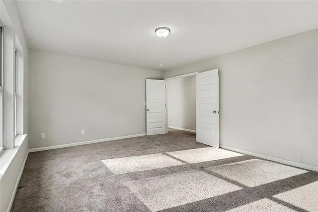 a view of a big room with closet and windows