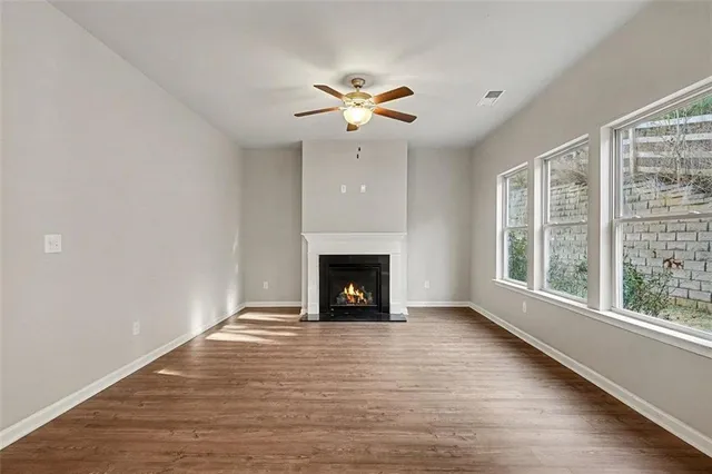 a view of an empty room with window and fire place