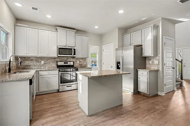 a kitchen with stainless steel appliances granite countertop a refrigerator stove and microwave