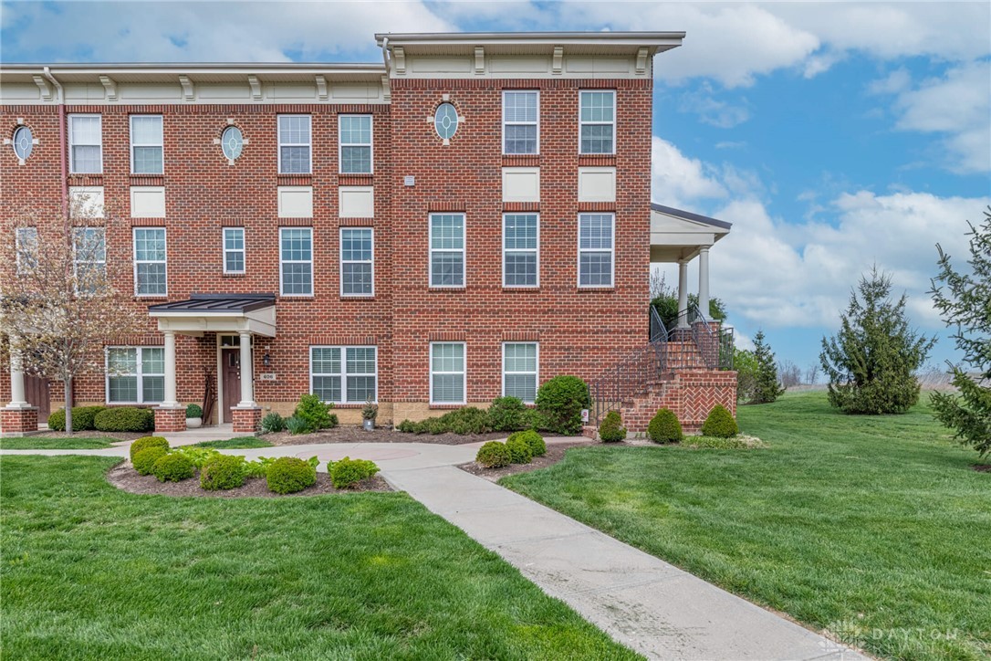 407 Brownstone Row Springboro, OH 45066 - Photo 2 of 54 This brick townhome offers a classic facade, manicured landscaping, and inviting pathways.