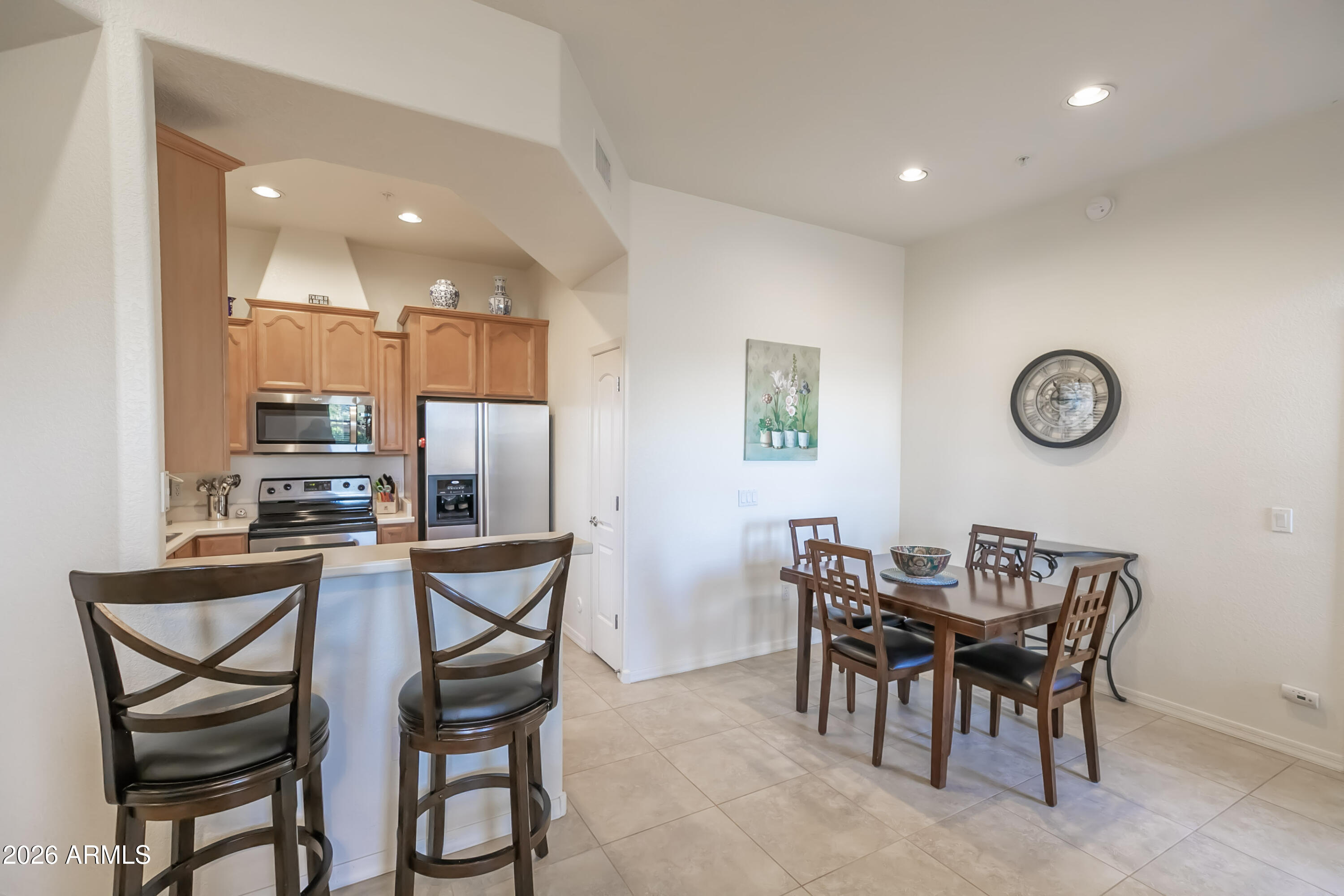 7027 North Scottsdale Road, Unit 132 Paradise Valley, AZ 85253 - Photo 4 of 48 a view of a dining room and kitchen with furniture and a clock