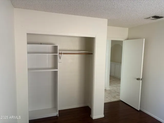 a room with a refrigerator and wooden floor