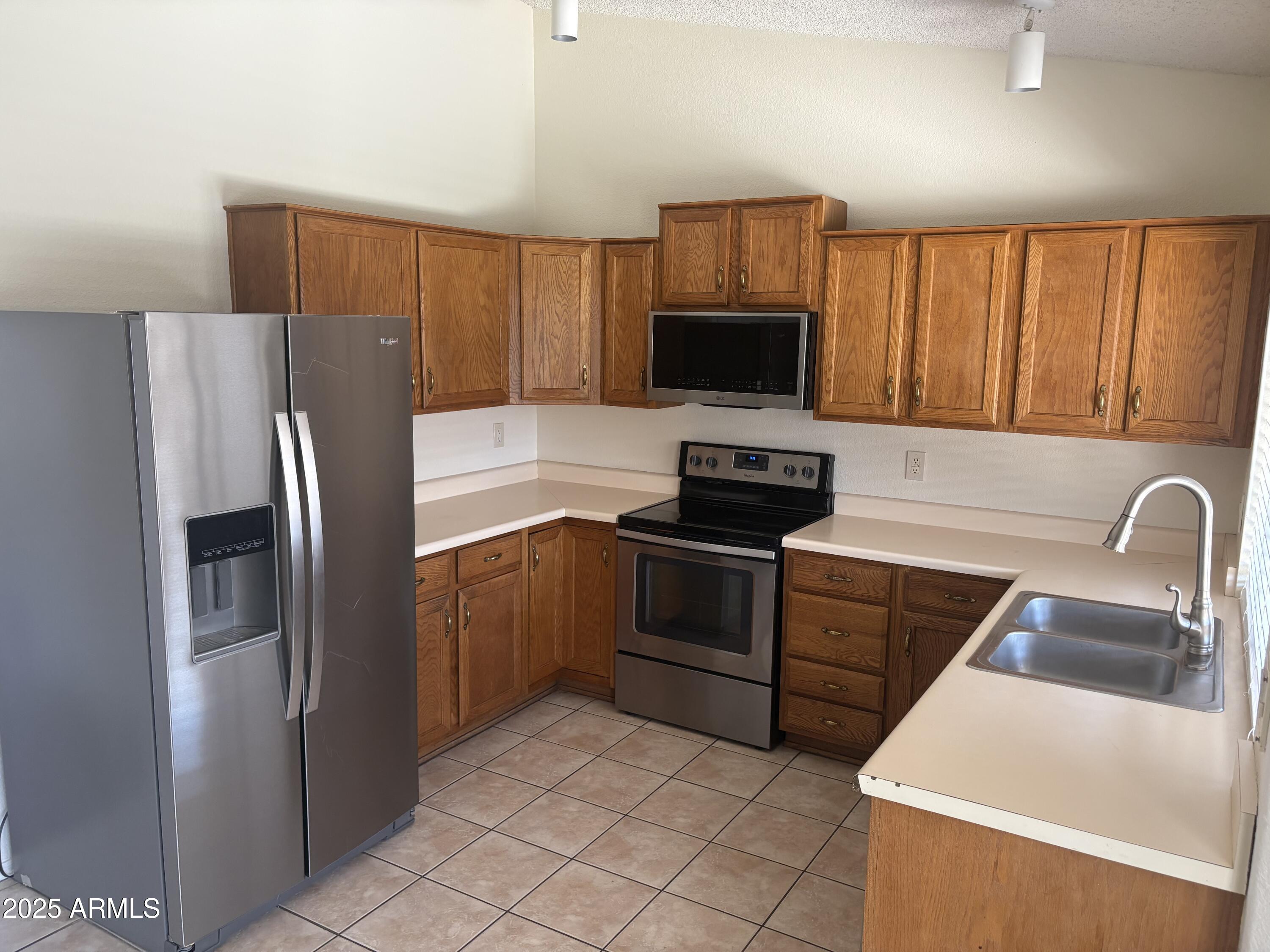 4661 West Whitten Street Chandler, AZ 85226 - Photo 6 of 17 a kitchen with stainless steel appliances a refrigerator stove and microwave