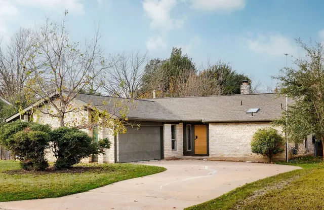 front view of a house with a yard and potted plants