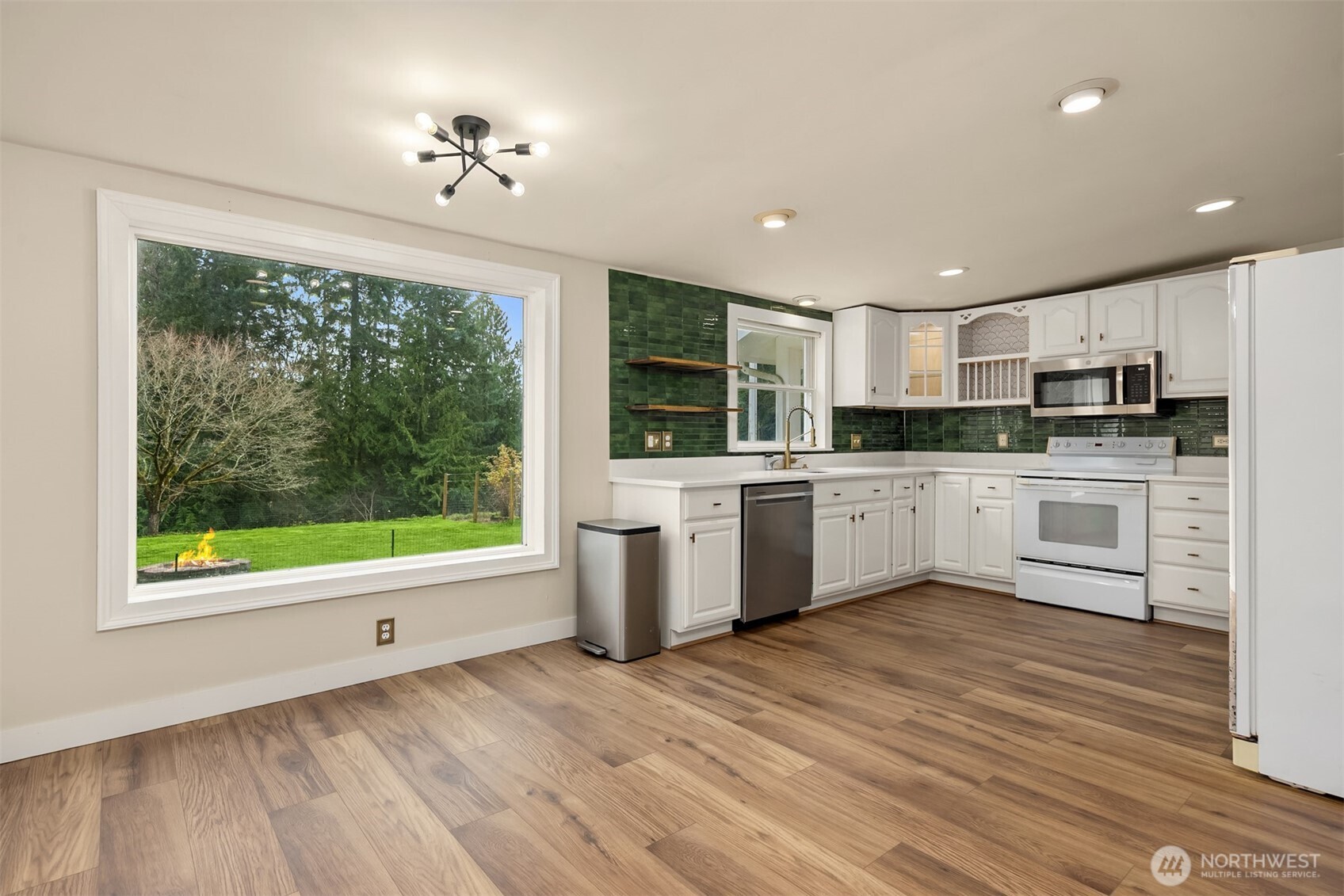 12620 Old Military Road Northeast Poulsbo, WA 98370 - Photo 11 of 35 a kitchen with a sink window and white cabinets