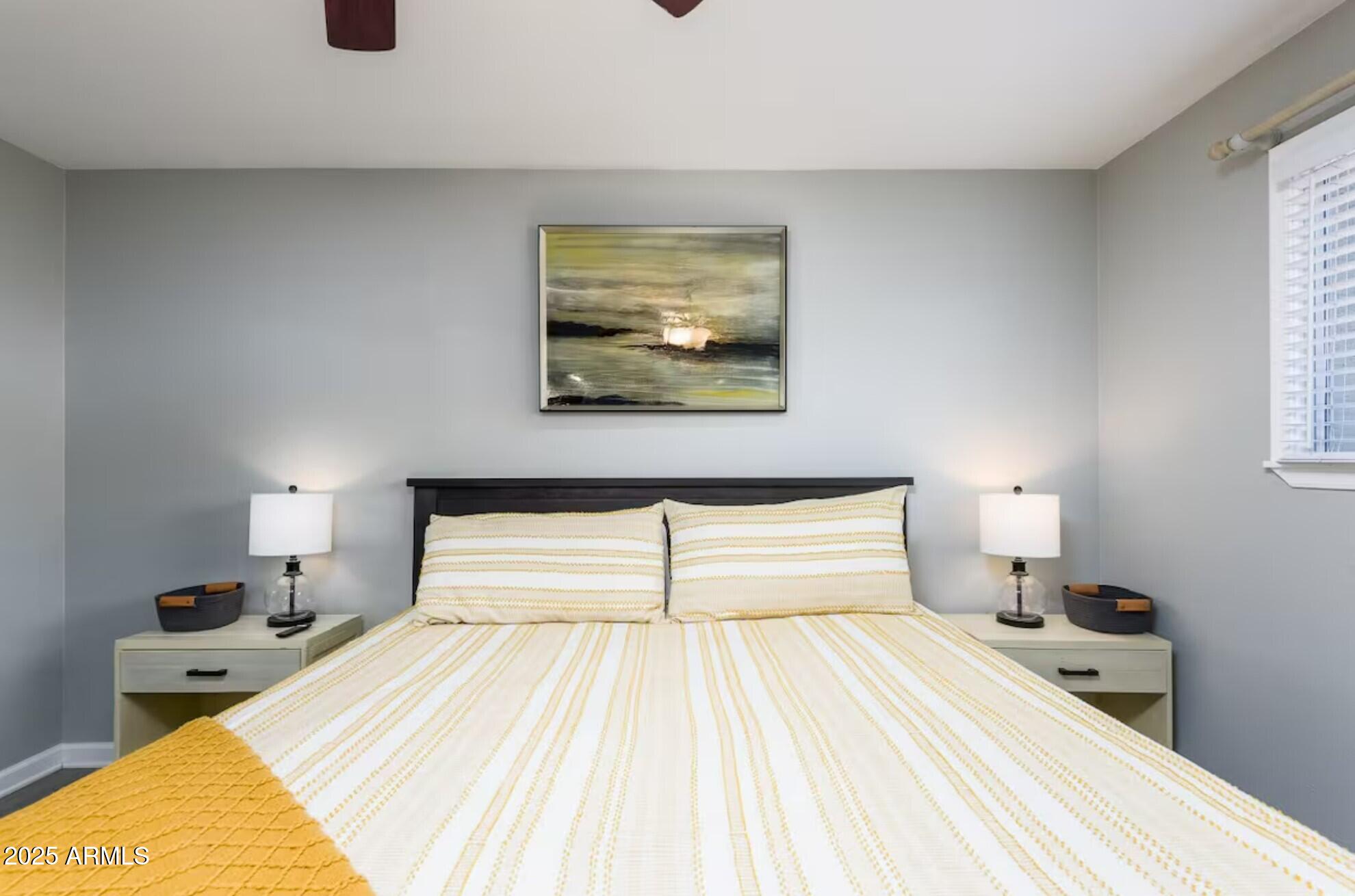 1612 West Geneva Drive Tempe, AZ 85282 - Photo 14 of 36 a bedroom with a large bed and a chandelier