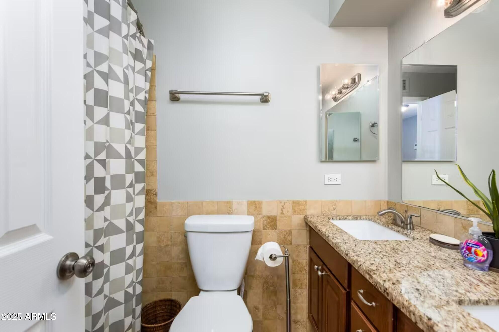 1612 West Geneva Drive Tempe, AZ 85282 - Photo 20 of 36 a bathroom with a granite countertop toilet sink and mirror