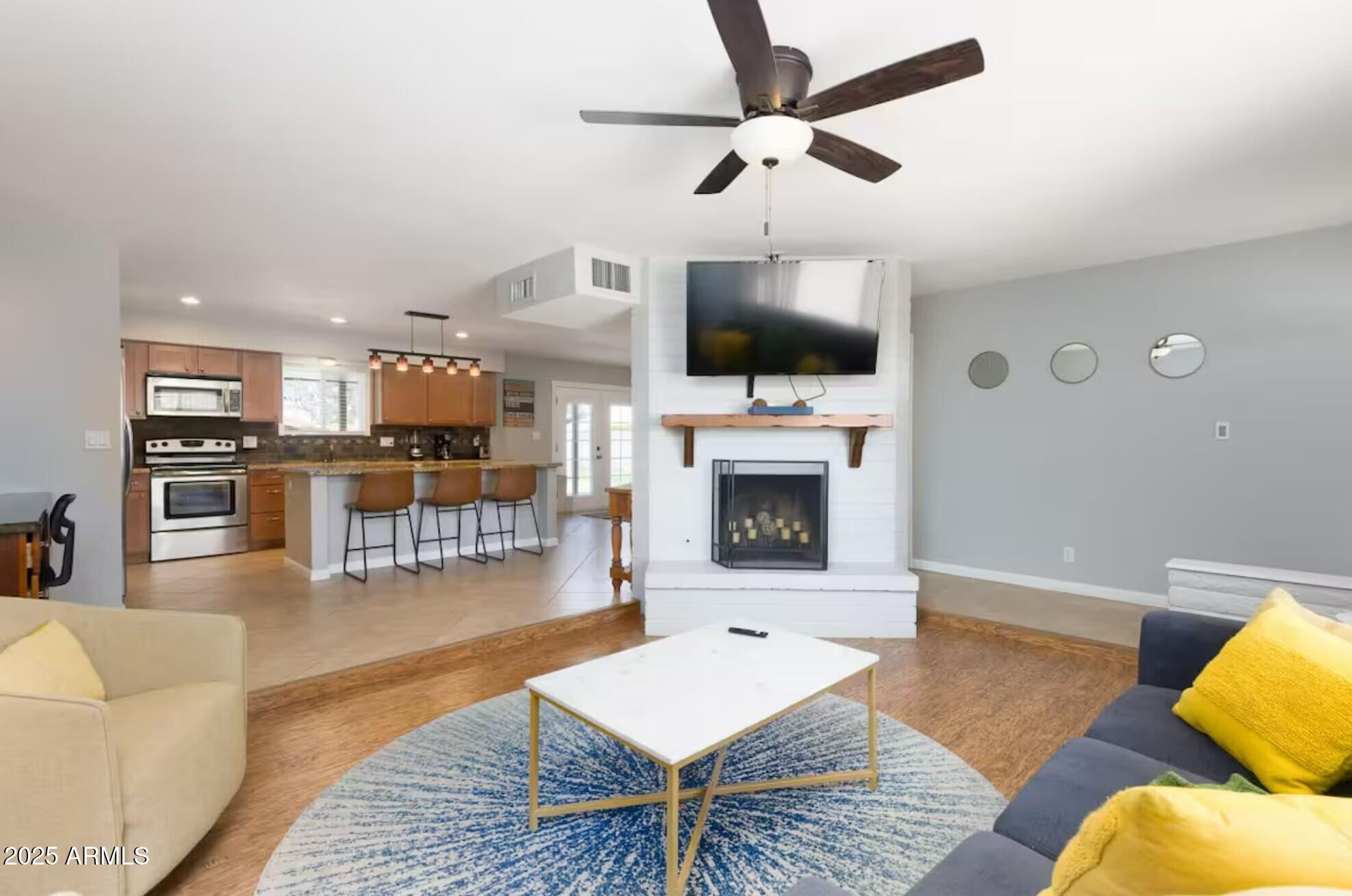 1612 West Geneva Drive Tempe, AZ 85282 - Photo 6 of 36 a living room with furniture a flat screen tv and kitchen view