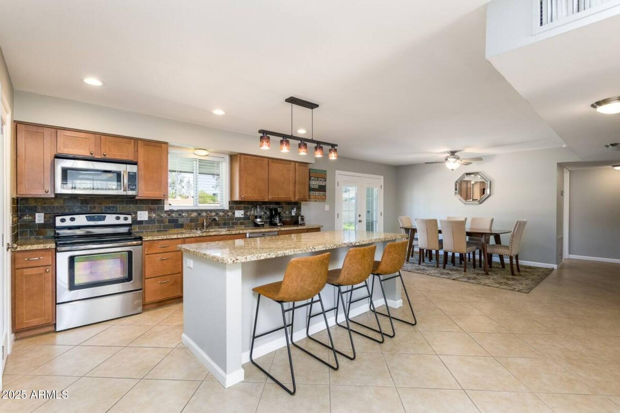 1612 West Geneva Drive Tempe, AZ 85282 - Photo 7 of 36 a kitchen with a dining table chairs and refrigerator