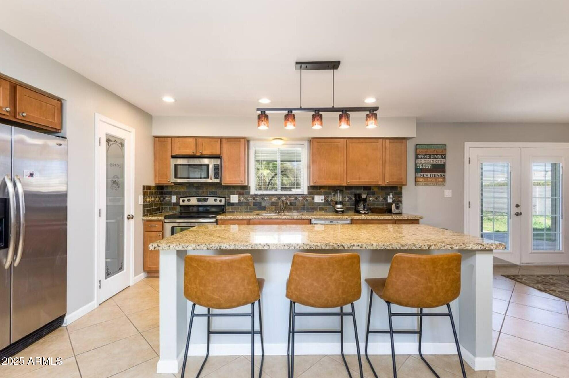 1612 West Geneva Drive Tempe, AZ 85282 - Photo 9 of 36 a kitchen with stainless steel appliances granite countertop a stove a sink and a refrigerator