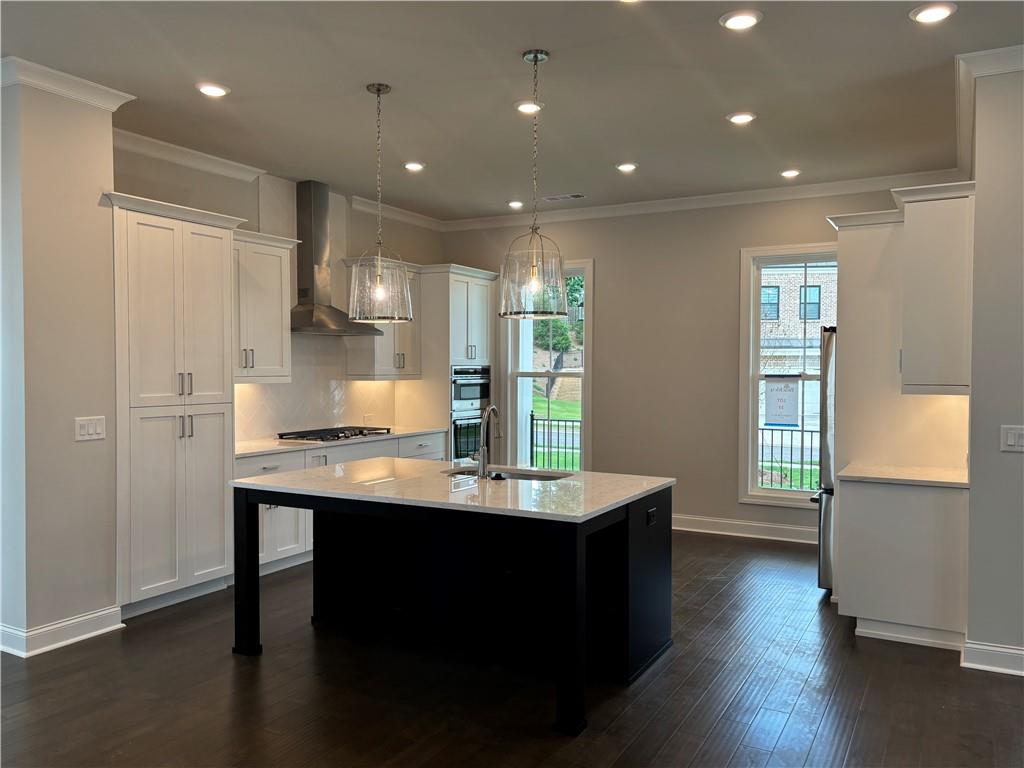 a kitchen with stainless steel appliances granite countertop a sink stove and wooden floor