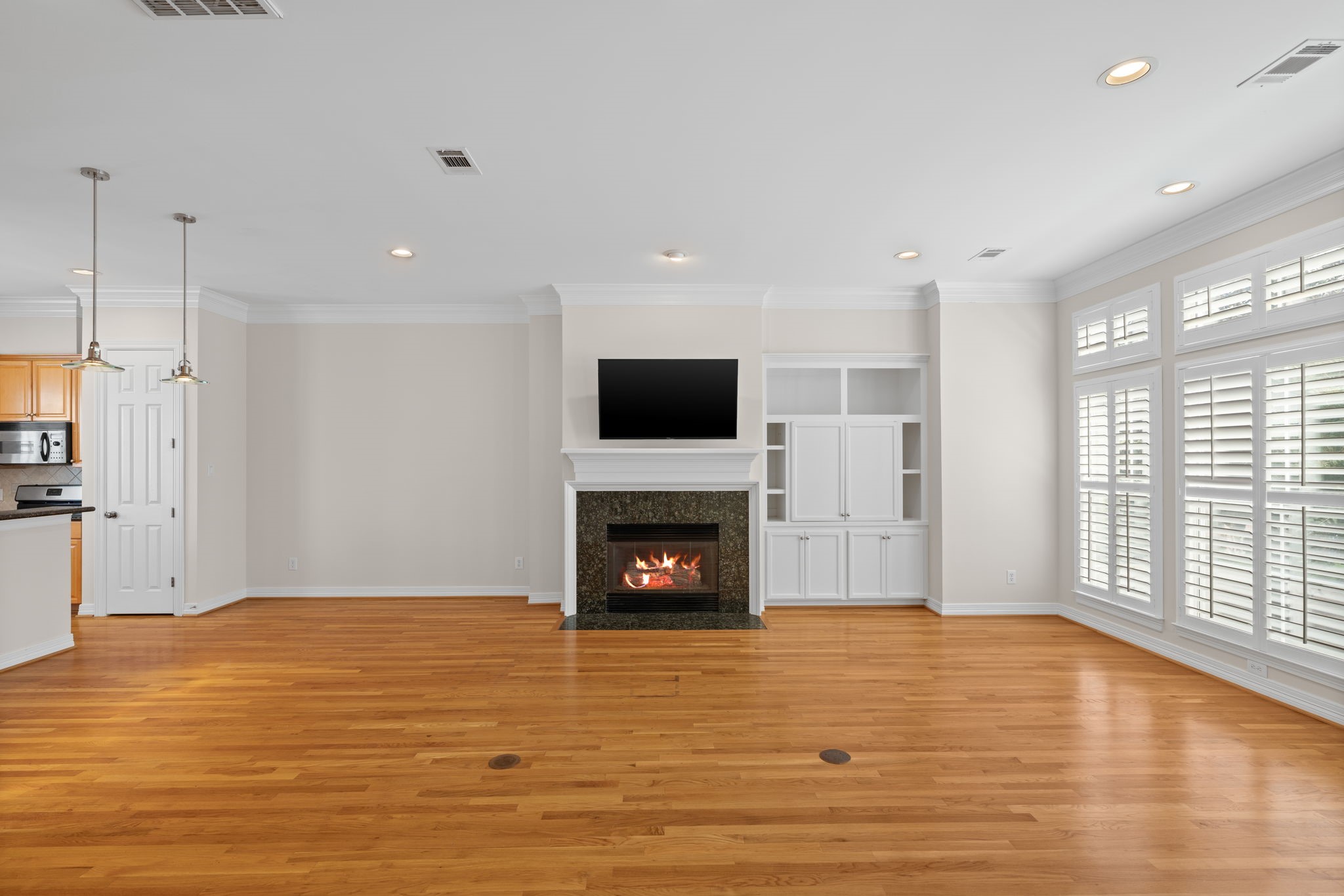 2196 Bancroft Lane Houston, TX 77027 - Photo 9 of 30 The fireplace is a striking focal point in this stunning family room. Beautiful flooring flows seamlessly throughout the space, creating a clean and modern foundation.