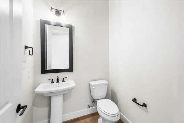 a large kitchen with kitchen island a stove a sink a center island and wooden floor