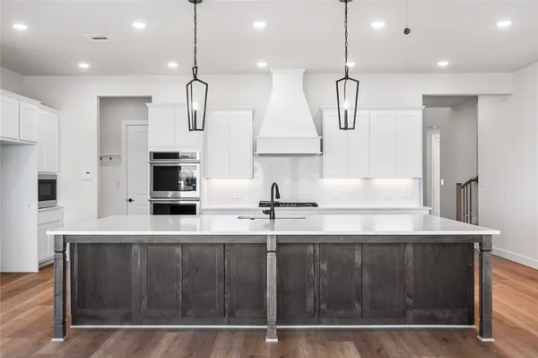 a view of a kitchen with a sink and wooden floor