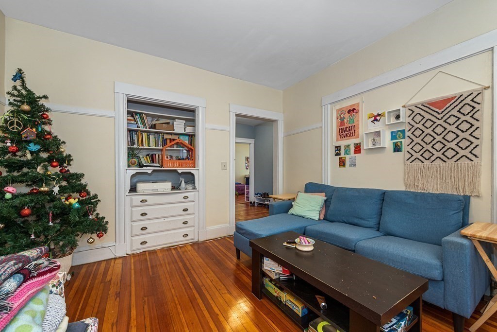 87 Parkton Road Boston, MA 02130 - Photo 24 of 42 a living room with furniture and a bookshelf with wooden floor