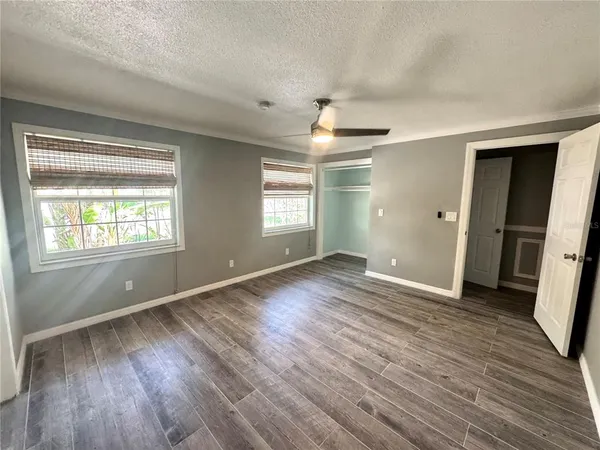 an empty room with wooden floor and windows