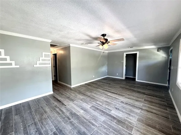 a view of empty room with wooden floor