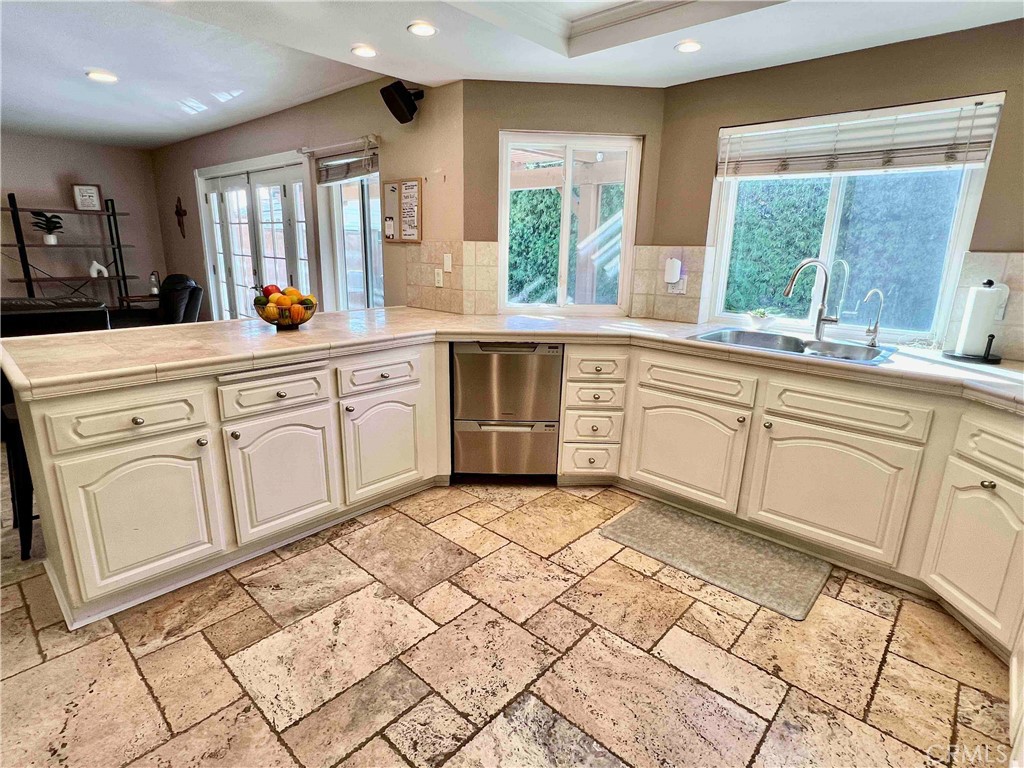 500 Silver Canyon Way Brea, CA 92821 - Photo 8 of 24 a large white kitchen with granite countertop a sink white cabinets and a large window