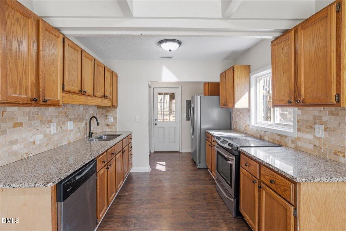 1423 Alderman Circle Raleigh, NC 27603 - Photo 24 of 37 a kitchen with granite countertop a sink stove and cabinets