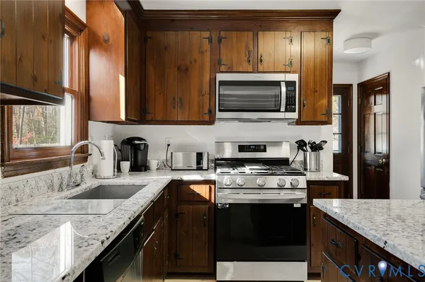 a kitchen with granite countertop stainless steel appliances and wooden cabinets