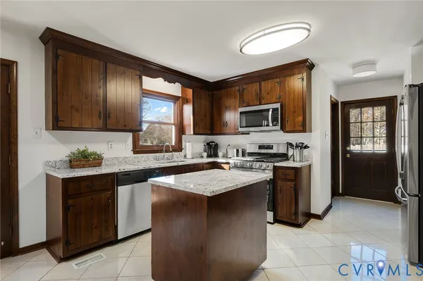 a kitchen with stainless steel appliances granite countertop a stove sink microwave and refrigerator