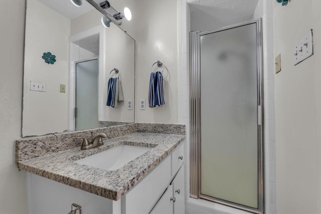 1421 South 12th Street, Unit 103 Waco, TX 76706 - Photo 12 of 17 a bathroom with a granite countertop sink and a mirror