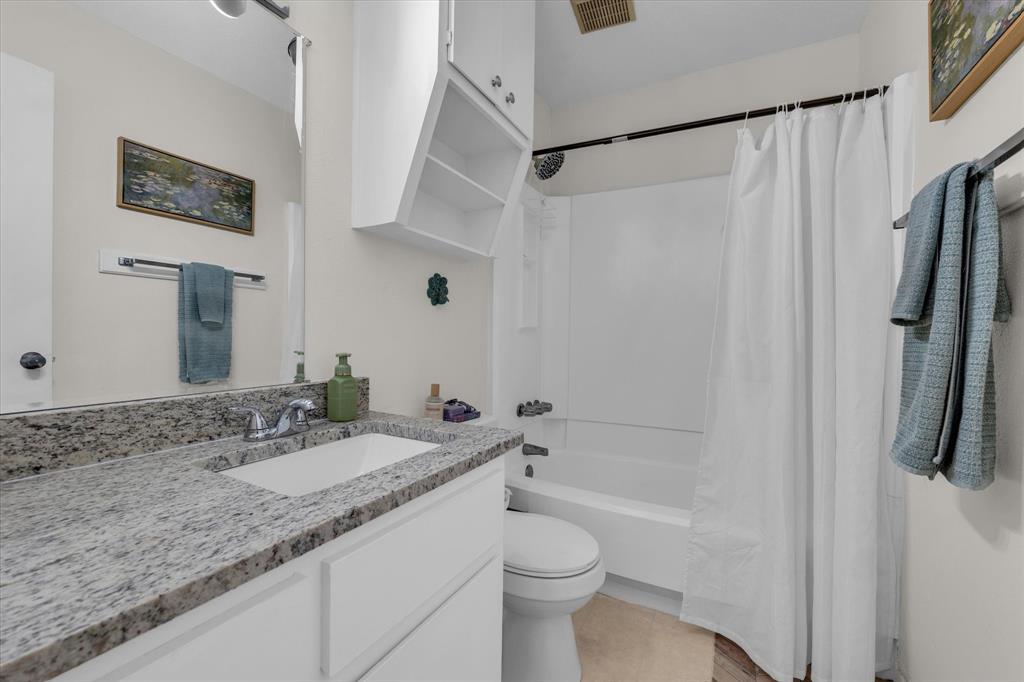 1421 South 12th Street, Unit 103 Waco, TX 76706 - Photo 15 of 17 a bathroom with a granite countertop sink toilet and shower