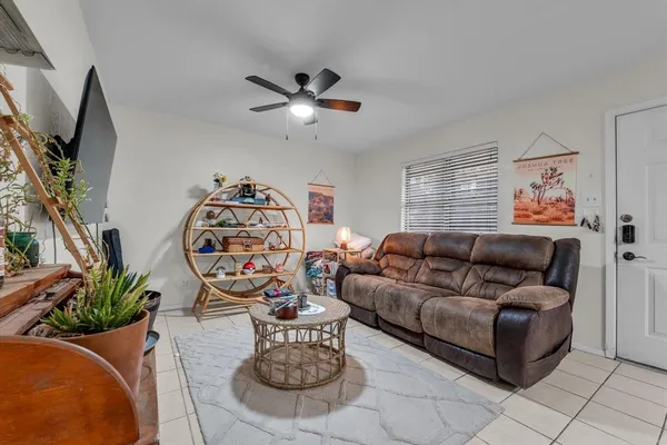 a living room with furniture a flat screen tv and a window