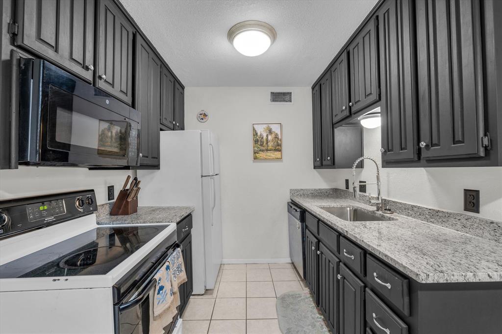 1421 South 12th Street, Unit 103 Waco, TX 76706 - Photo 7 of 17 a kitchen with granite countertop a sink stove and cabinets