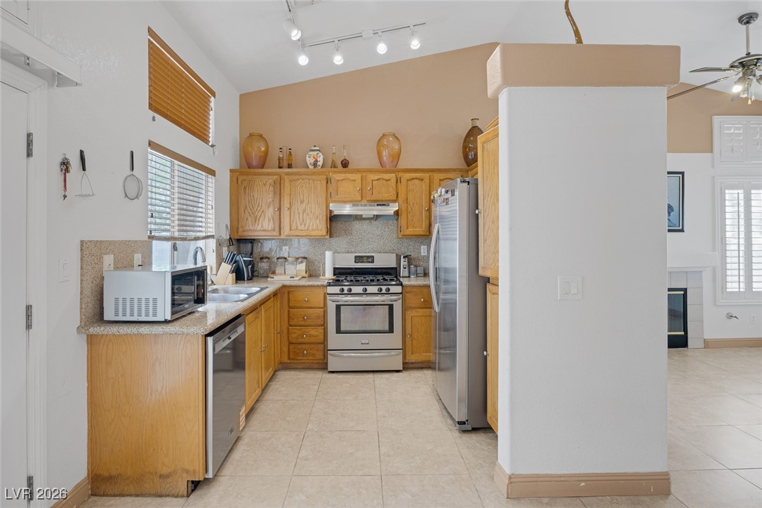 2427 Worchester Road Henderson, NV 89074 - Photo 14 of 35 Kitchen with stainless steel appliances, healthy amount of natural light, light tile patterned flooring, and lofted ceiling