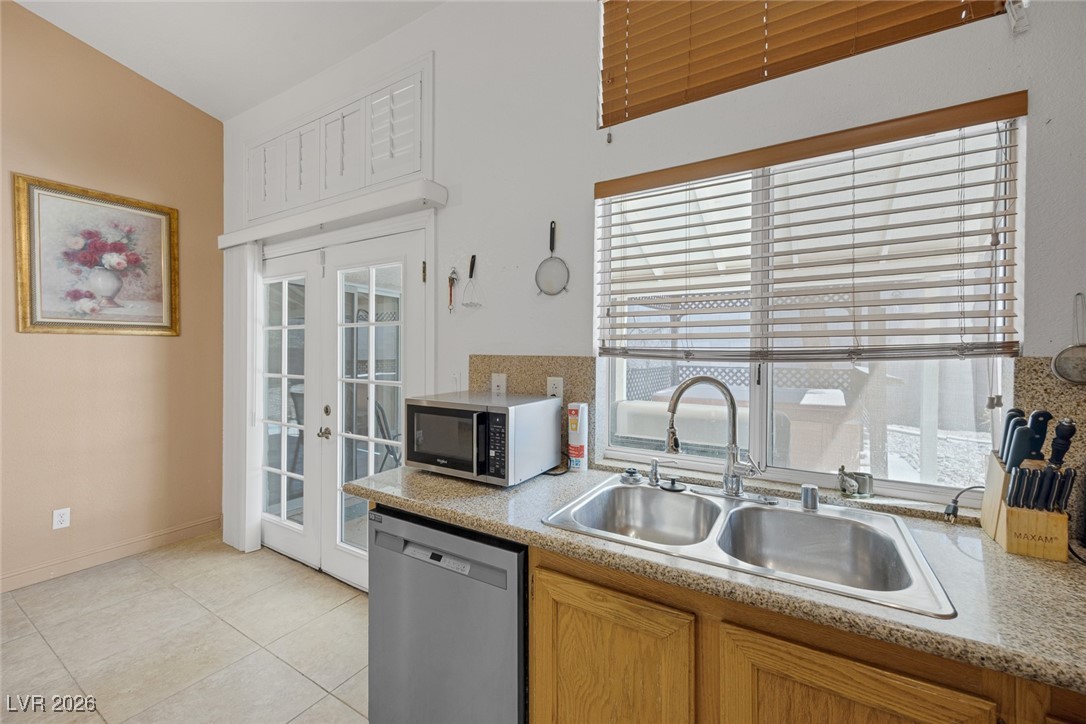 2427 Worchester Road Henderson, NV 89074 - Photo 16 of 35 Kitchen featuring stainless steel appliances, light countertops, french doors, and light tile patterned floors