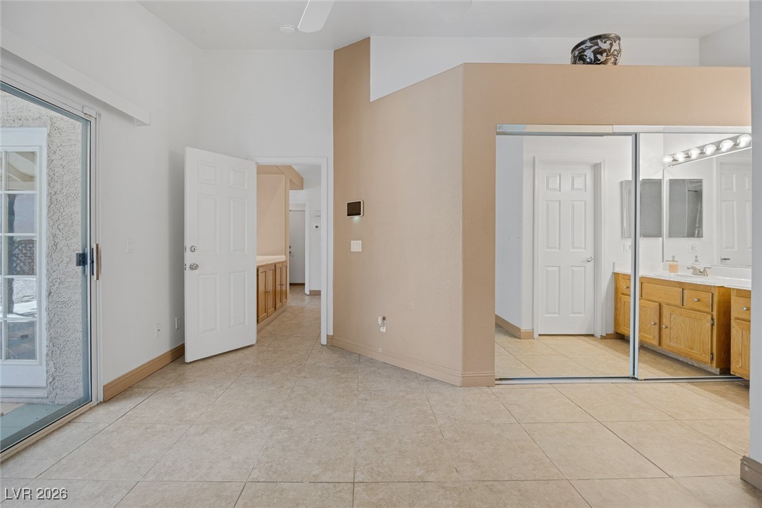2427 Worchester Road Henderson, NV 89074 - Photo 19 of 35 Unfurnished bedroom featuring access to outside, ceiling fan, light tile patterned flooring, and a closet