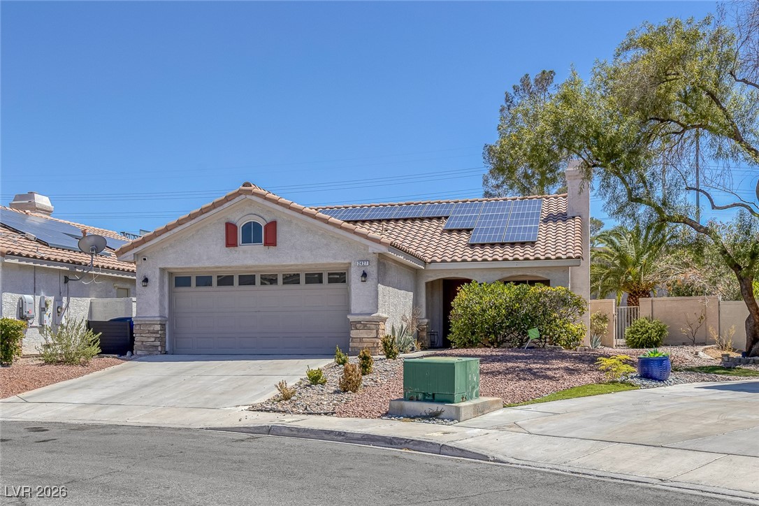 2427 Worchester Road Henderson, NV 89074 - Photo 2 of 35 Mediterranean / spanish house with stone siding, solar panels, concrete driveway, a chimney, and stucco siding