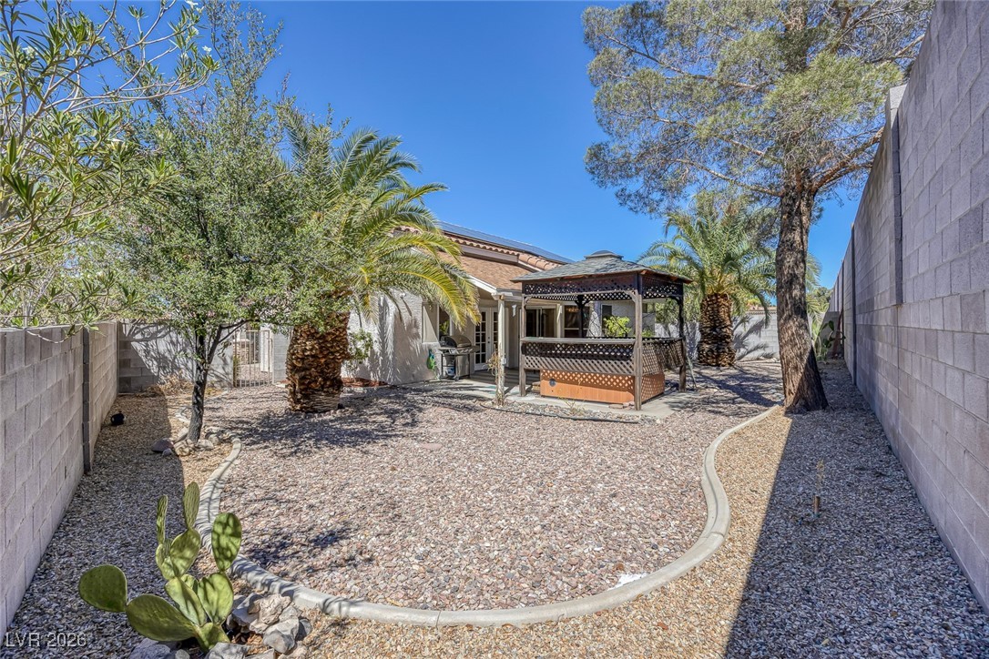 2427 Worchester Road Henderson, NV 89074 - Photo 28 of 35 Back of house featuring a gazebo, a fenced backyard, roof mounted solar panels, a deck, and a patio area