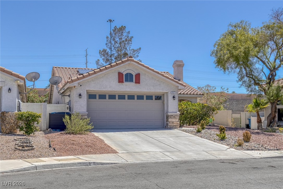 2427 Worchester Road Henderson, NV 89074 - Photo 3 of 35 Mediterranean / spanish-style house with stucco siding, a tiled roof, driveway, and a garage