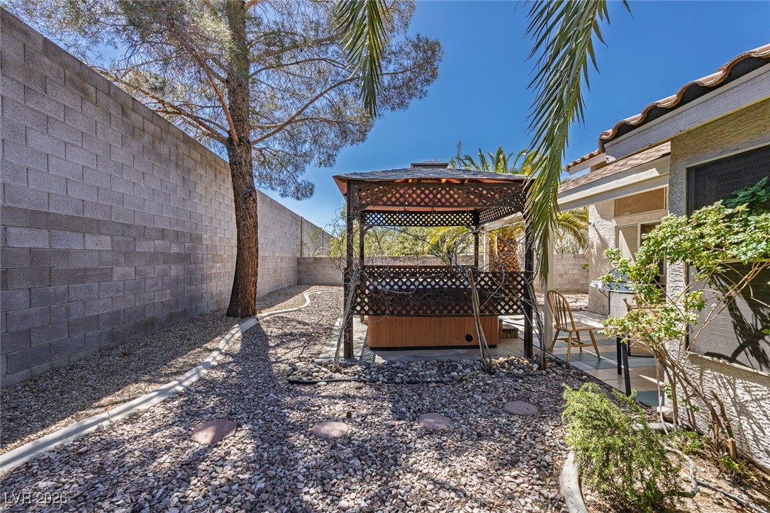 2427 Worchester Road Henderson, NV 89074 - Photo 32 of 35 Fenced backyard featuring a patio area, a gazebo, and a hot tub