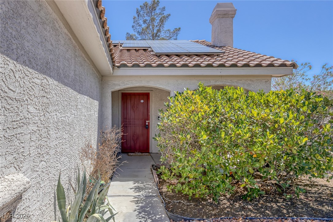 2427 Worchester Road Henderson, NV 89074 - Photo 4 of 35 Property entrance featuring stucco siding, solar panels, and a tiled roof