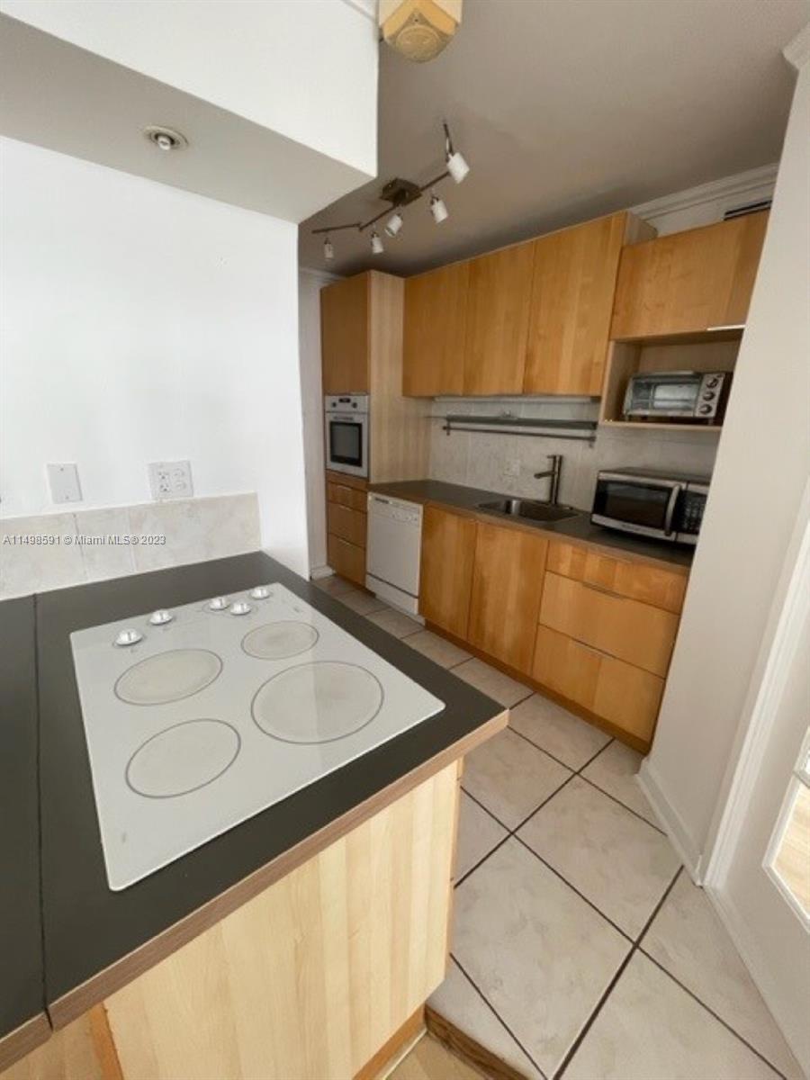 Millionaire's Row Miami Beach, FL 33140 - Photo 2 of 16 a kitchen with stainless steel appliances granite countertop a sink and a stove
